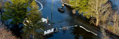 Aerial view of a residential area experiencing flooding with several homes surrounded by water.
