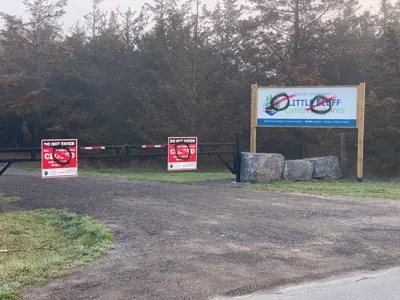 Banner reading "Little Bluff Conservation Area" above a closed gate with signs saying "Do Not Enter" and "Closed" at the entrance to a natural park area.