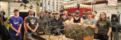 Students from PECI stand behind the three Windermere Traps that they re-verse engineered and fabricated using their welding skills