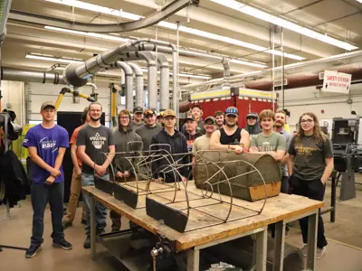Students from PECI stand behind the three Windermere Traps that they re-verse engineered and fabricated using their welding skills